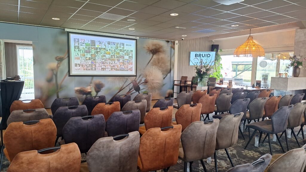 Zaal met stoelen in theateropstelling en een scherm