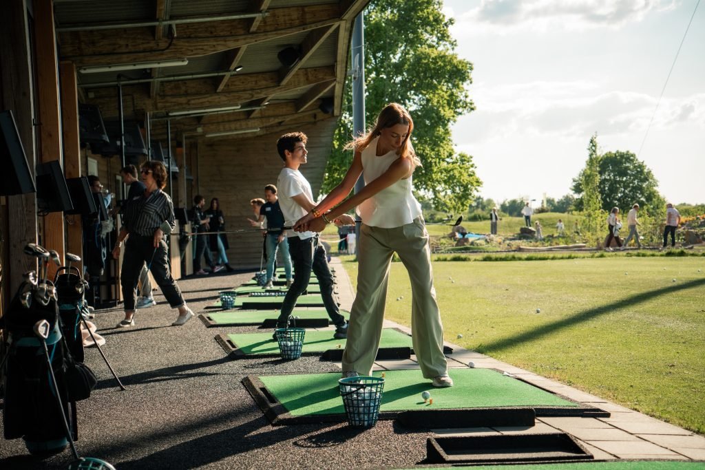 Vrouw slaat een bal op een afslagmat