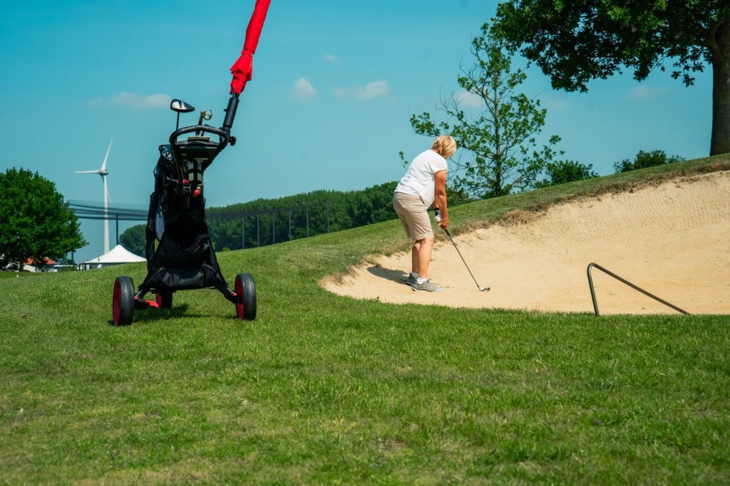 Vrouw slaat uit de bunker op golfbaan Harderwold