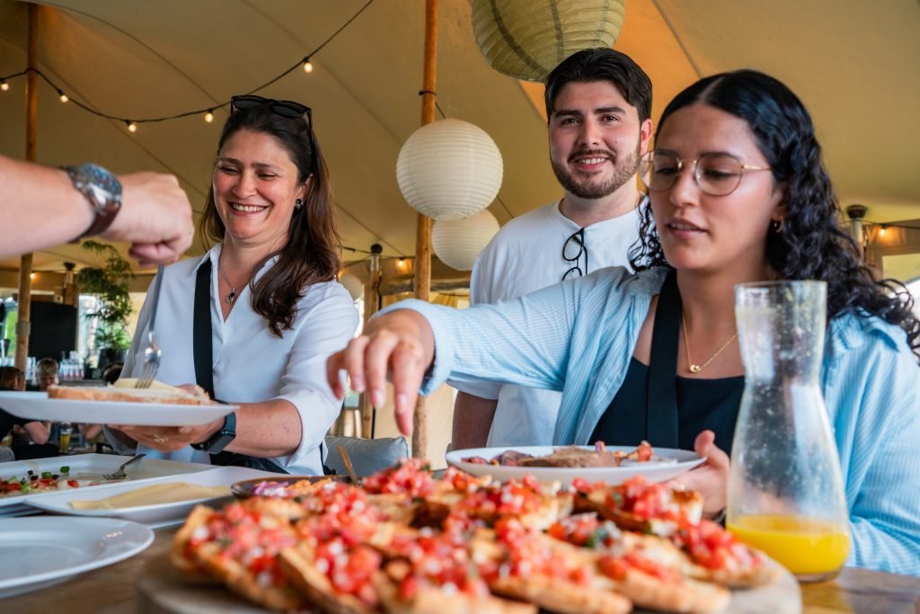 Lachende gasten aan tafel met bruschetta