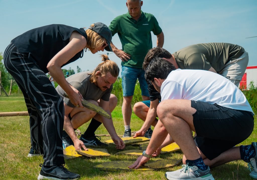 Groep puzzelt met gele stukken op het gras