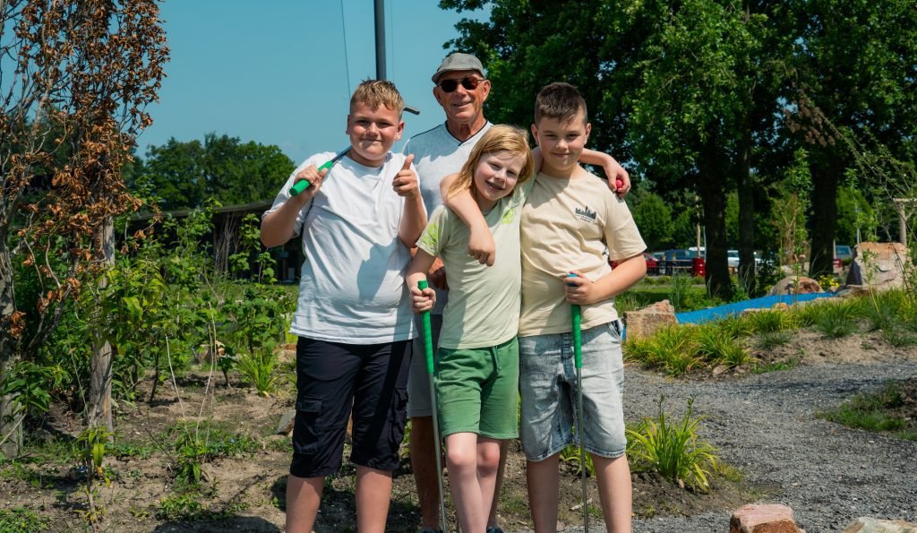 Drie mannen met golfclubs poseren