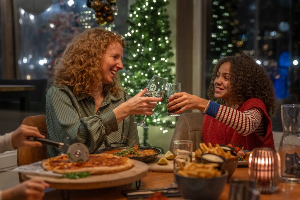 Mensen aan tafel bij de kerstboom