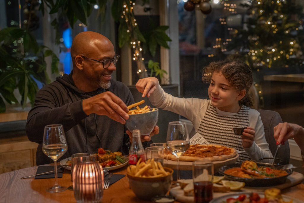Gezelschap eet samen aan een feestelijk gedekte tafel