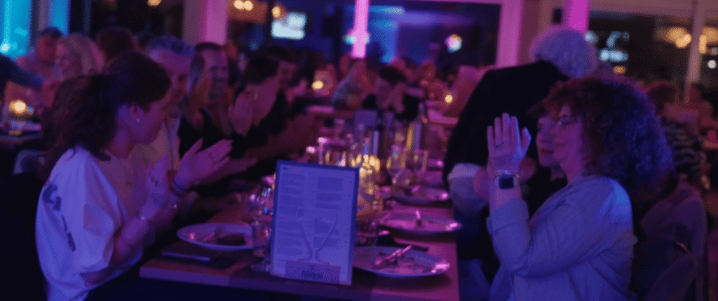 Gedekte tafels in een zaal met paarse verlichting