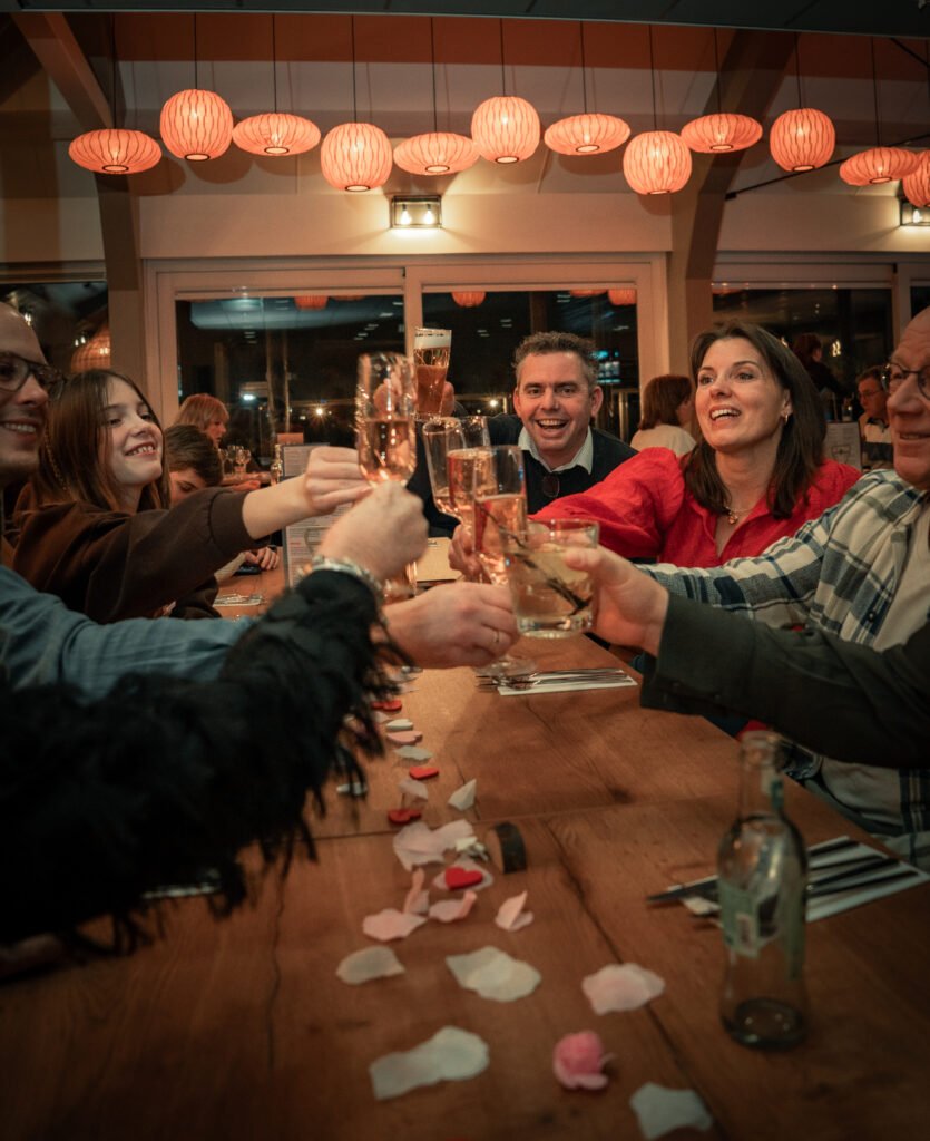 Groep proost aan tafel onder lampionnen